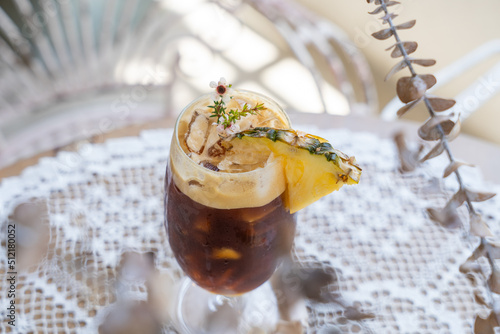 selective focus, Glass of iced drink on table, summer cocktail recipe, refreshment concept. Cold drink Black Coffee is the New exotic Iced Coffee With Pineapple Juice.