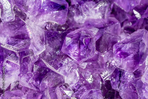 Amethyst purple crystals. Gems. Mineral crystals in the natural environment. Texture of precious and semiprecious stones. Seamless background with copy space colored shiny surface of precious stones. photo