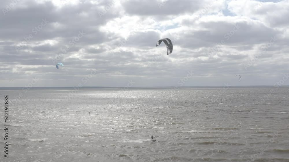 Ukraine. Kyiv. Athletes ride kite surfin. Kiev sea. Summer. Windy weather. Competition. Colored sails. Aerial. Ukraine. Kyiv. Athletes ride kite surfin. Kiev sea. Summer. Windy weather. Competition. Colored sails. Aerial.