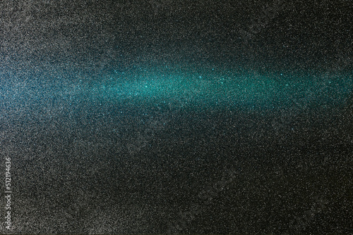 On a gray background in fine grain, a gradient light blue horizontal beam of light