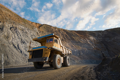 Large dump truck driving on the track through quarry