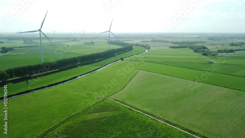 view of landscape with greenfields and windmills in the Netherlands