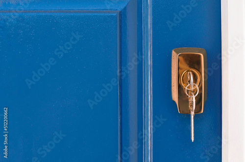Konstfotografi Metal keys in golden lock fro. blue door. High quality photo