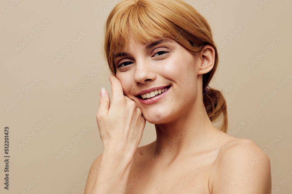 a close horizontal photo with an empty space of a pleasant, lovely woman with perfect skin standing on a background gently touching her face with her hands, smiling broadly at the camera a close horizontal photo with an empty space of a pleasant, lovely woman with perfect skin standing on a background gently touching her face with her hands, smiling broadly at the camera