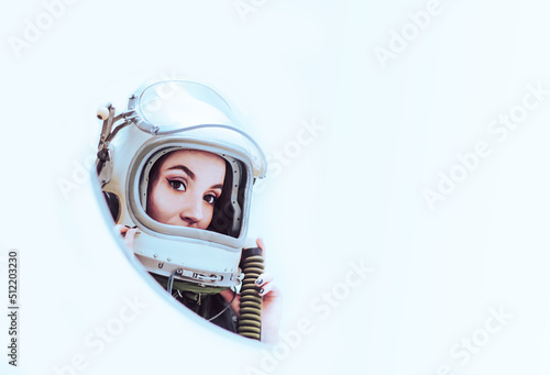 Isolated on white background. Cute girl studying information in the tablet. Astronaut girl in a space suit. Free space for text. Space helmet. White isolated. Space girl.