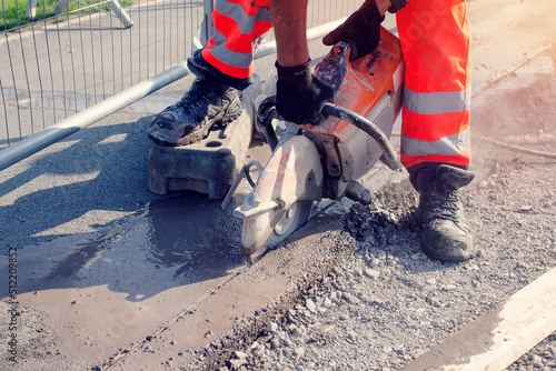 Groundworker cutting road with petrol saw photo