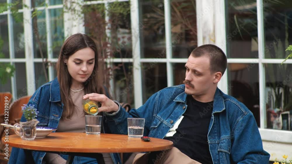 A young couple Denim clothes On a date in a vintage restaurant outside They are talking A young couple Denim clothes On a date in a vintage restaurant outside They are talking