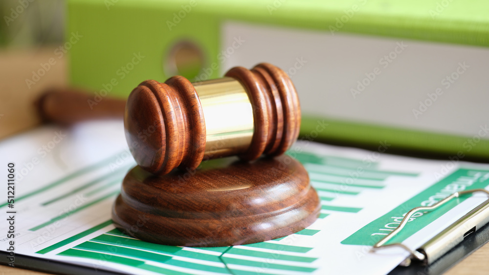 Judge hammer on business statistics documents with charts and graphs Judge hammer on business statistics documents with charts and graphs