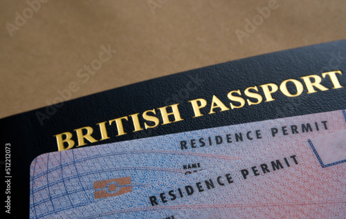 Biometric Residence permit Cards (Indefinite leave to Remain, ILR) placed on top of British passport. Concept for naturalization. Stafford, United Kingdom, July 20, 2022