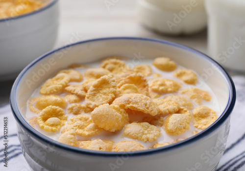 Tasty cornflakes with milk in bowl on table, closeup © New Africa
