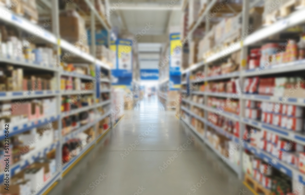 Blurred supermarket aisle with colorful shelves of merchandise. 