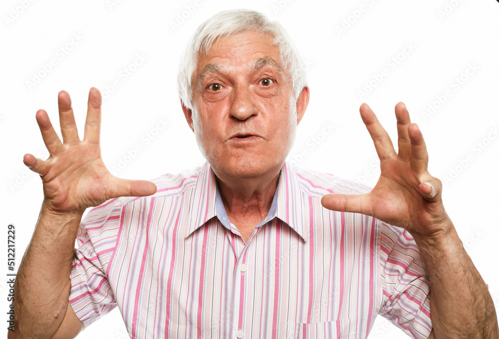 Emotion, old people and body language concept: An elderly man is surprised and annoyed, trying to scare with outstretched palms Emotion, old people and body language concept: An elderly man is surprised and annoyed, trying to scare with outstretched palms
