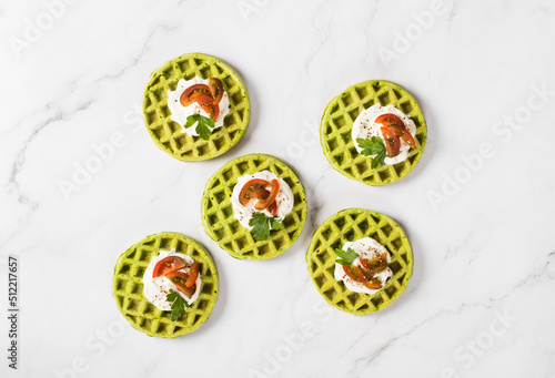 Round Spinach waffles with cottage cheese, cherry tomatoes and parsley. Light background. Top view
