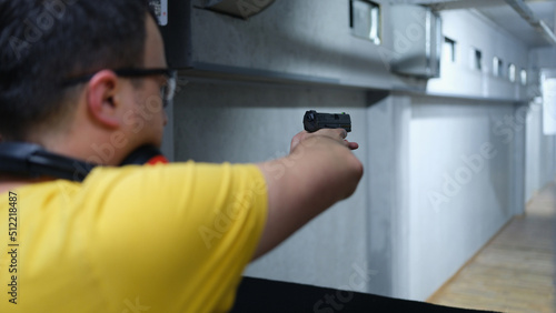 Man aiming pistol at target in shooting range