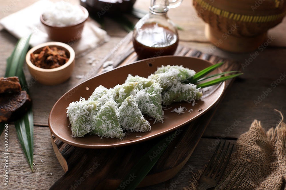 Lupis, Indonesian Traditional Snack Made From Sticky Rice, Wrapped with Banana Leaf, Shape Triangle Served with Liquid Palm Sugar and Grated Coconut Lupis, Indonesian Traditional Snack Made From Sticky Rice, Wrapped with Banana Leaf, Shape Triangle Served with Liquid Palm Sugar and Grated Coconut