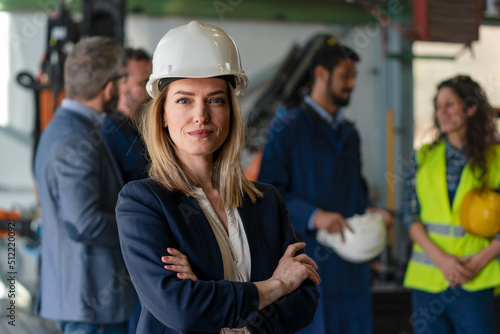 Portrait of female chief engineer in modern industrial factory looking at camera.