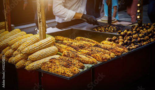 Photography Fried grilled corn at a street food market kiosk.