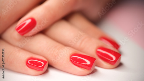 Woman hands with perfect bright red glossy manicure
