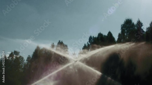 watering the lawn in slow motion on the golf course from two sides