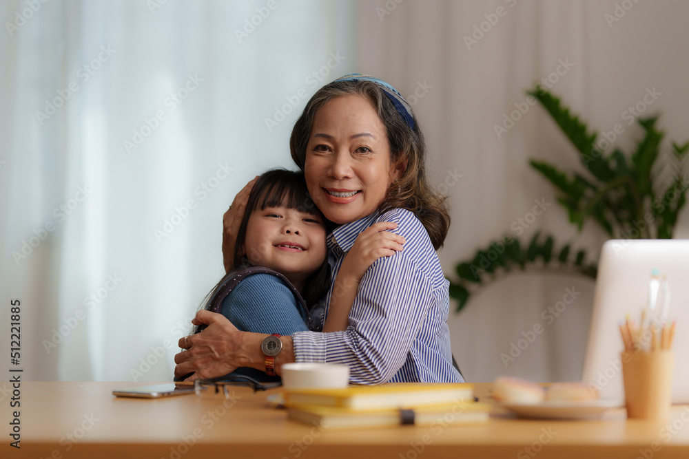 Happy moments of Granddaughter give hug while Asian senior business woman working at home. Family concept. Happy moments of Granddaughter give hug while Asian senior business woman working at home. Family concept.