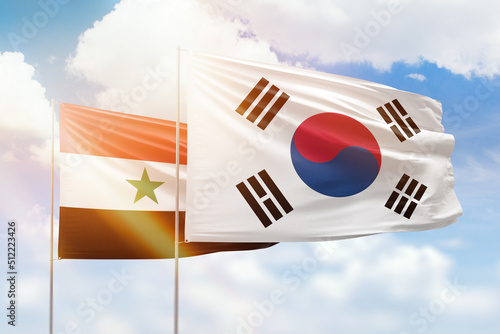 Sunny blue sky and flags of south korea and syria