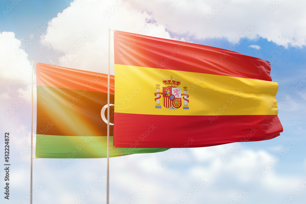 Fototapeta premium Sunny blue sky and flags of spain and libya