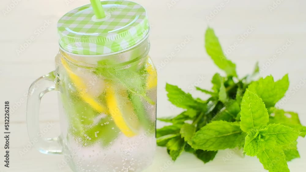summer drink. Sassy lemon water.Dietary lemon drink. Lemon mint water with ice in a transparent misted mug.Citrus cocktail with mint leaves. Slow motion. High quality 4k footage summer drink. Sassy lemon water.Dietary lemon drink. Lemon mint water with ice in a transparent misted mug.Citrus cocktail with mint leaves. Slow motion. High quality 4k footage
