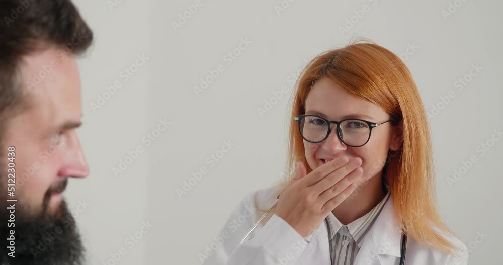 Woman doctor sneezes during consult patient in office Woman doctor sneezes during consult patient in office