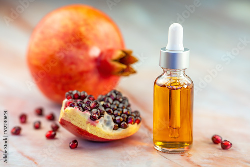 Fotografie Pomegranate oil in a cosmetic bottle with a pipette