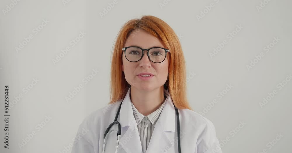 Woman doctor with glasses smiles and gives advice looking at camera Woman doctor with glasses smiles and gives advice looking at camera