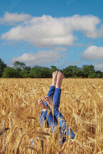 Obraz na płótnie Children's legs sticking out in the field w salonie