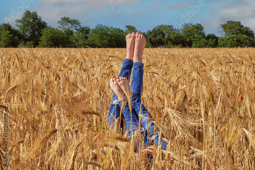 Obraz na płótnie Children's legs sticking out in the field w salonie
