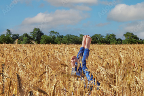 Obraz na płótnie Children's legs sticking out in the field w salonie