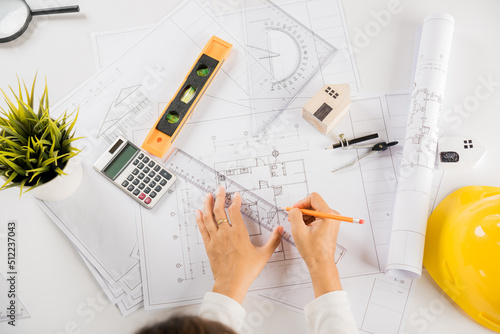 Architectural project workplace. Architect drawing with ruler on house plan blueprint paper for repair tools on table desk at architecture office, architect sketching construction, Engineering tools