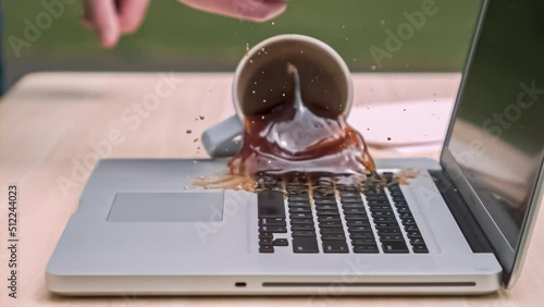Title: Cup of coffee spilling on a laptop keyboard in slow motion; 4k 1000fps