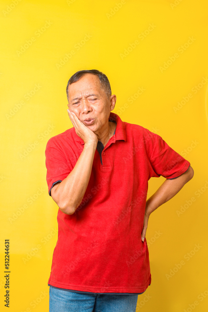 Asian senior man suffers from toothache isolated on yellow background. Asian senior man suffers from toothache isolated on yellow background.