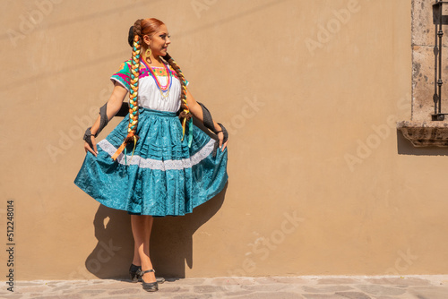 Portrait of a Mexican woman wearing a traditional dress for folk dance photo