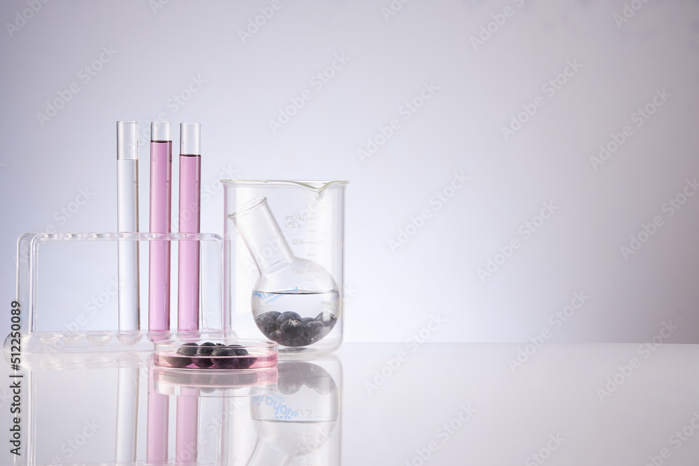 Front view of blueberry extract decorated with transparent podium and glassware blank space in white background Front view of blueberry extract decorated with transparent podium and glassware blank space in white background