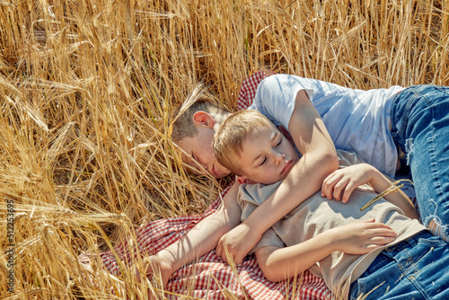 Obraz na płótnie Two children are sleeping in a field of wheat. Brothers relaxing outdoors w salonie