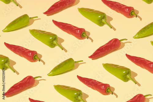 Minimal composition pattern background of red and green peppers on a light yellow background. Summer healthy food concept.