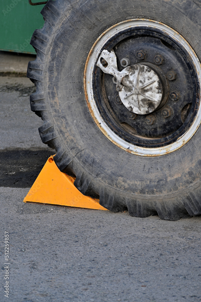The truck wheel on the slope is fixed with a stop for safe parking The truck wheel on the slope is fixed with a stop for safe parking