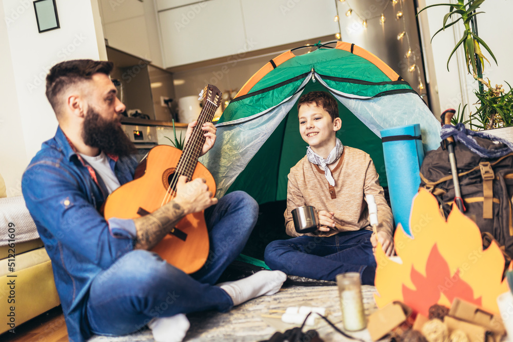 Obraz premium Father and son playing and having fun with camping tent in their living room.