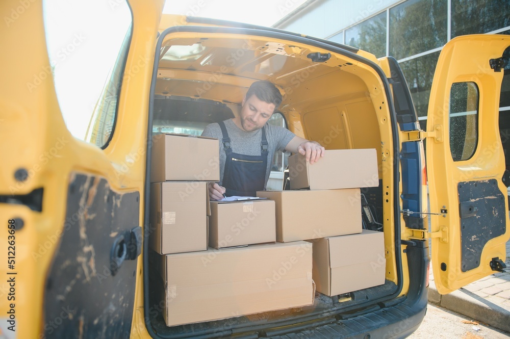 The courier brought the delivery of the box to the client. Courier service employee in uniform. The courier brought the delivery of the box to the client. Courier service employee in uniform.