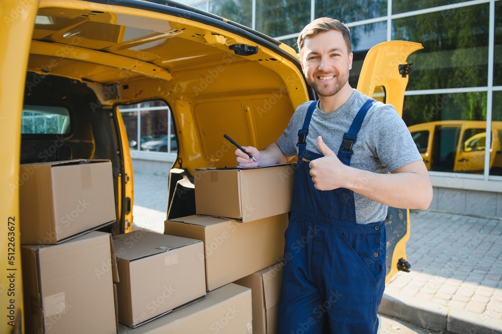 The courier brought the delivery of the box to the client. Courier service employee in uniform. The courier brought the delivery of the box to the client. Courier service employee in uniform.