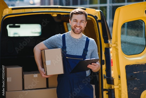 Delivery men unloading moving boxes from car photo