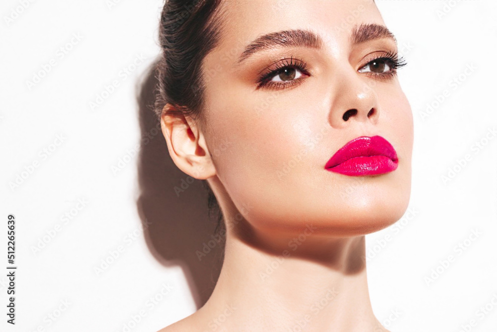 Fashion beauty portrait of young brunette woman with evening stylish makeup and perfect clean skin. Sexy model with hair in a bun posing in studio. With pink bright natural lips. Isolated on white Fashion beauty portrait of young brunette woman with evening stylish makeup and perfect clean skin. Sexy model with hair in a bun posing in studio. With pink bright natural lips. Isolated on white