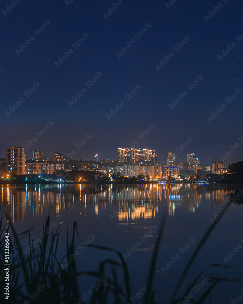 Beautiful view of the night city. Right bank of the Dnieper, lights in the night river. View of beautiful modern buildings.