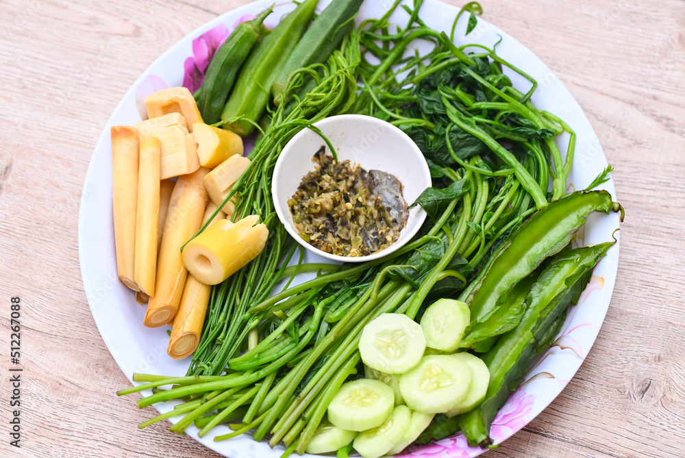 steamed vegetables on plate and wooden background , Asian Thai food with steamed or boiled vegetables with Cucumber Bamboo shoots Acacia pennata Okra Winged Bean Ceylon Spinach and chili sauce steamed vegetables on plate and wooden background , Asian Thai food with steamed or boiled vegetables with Cucumber Bamboo shoots Acacia pennata Okra Winged Bean Ceylon Spinach and chili sauce