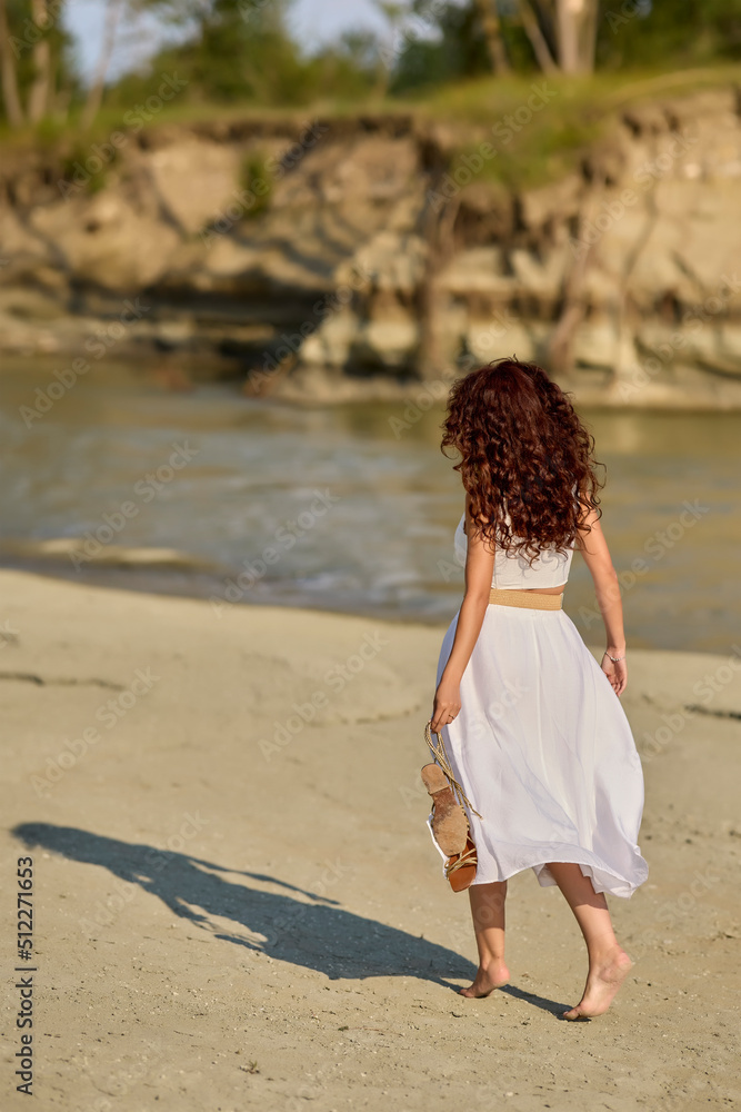 Beautiful woman in white dress on the bank of a river in summer. Beautiful woman in white dress on the bank of a river in summer.
