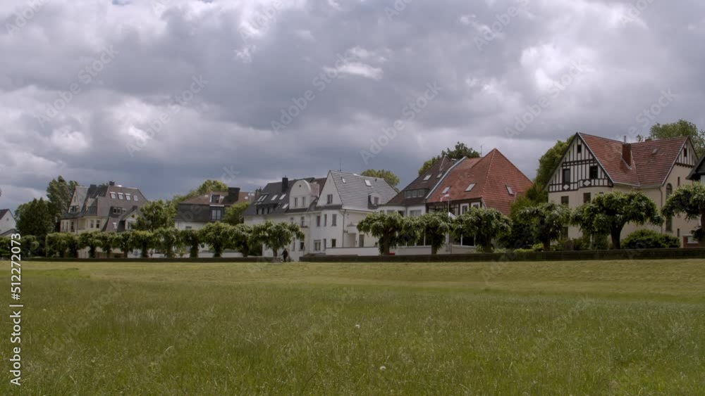 First row of houses panorama on Rhine river in Rodenkirchen, Germany with trees and meadow in summer 2019 First row of houses panorama on Rhine river in Rodenkirchen, Germany with trees and meadow in summer 2019